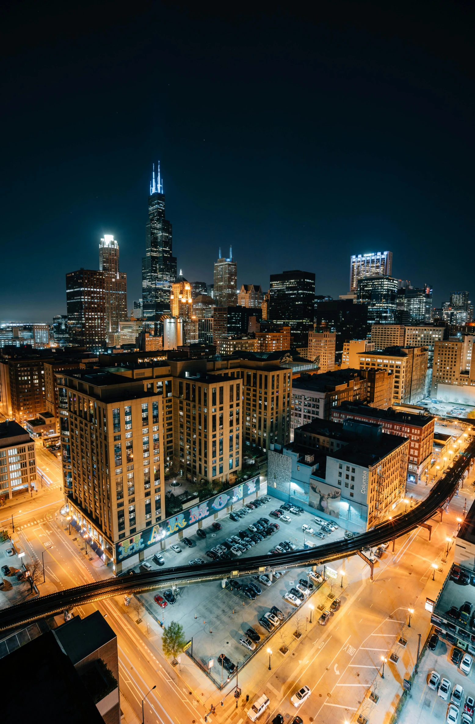 an aerial view of a city at night, a photo, by Andrew Domachowski, unsplash contest winner, from wheaton illinois, skyline view from a rooftop, sparsely populated, high light on the left