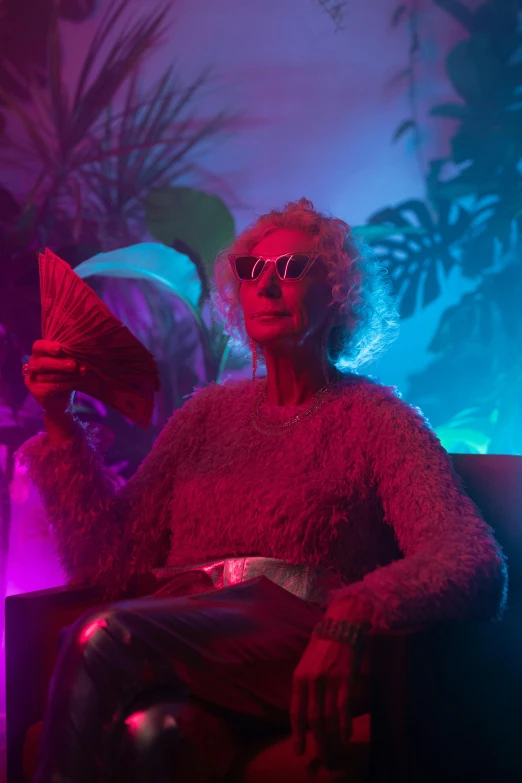 a man sitting on top of a couch in a living room, an album cover, inspired by Elsa Bleda, pexels contest winner, older woman, holographic neon highlights, cinematic outfit photo, elderly woman
