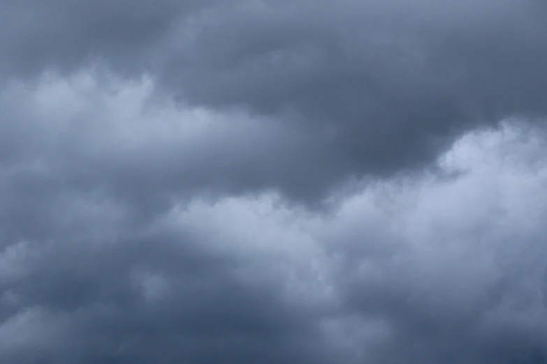 a large jetliner flying through a cloudy sky, an album cover, pexels, minimalism, rain stormy fog, hd footage, mammatus clouds, gray