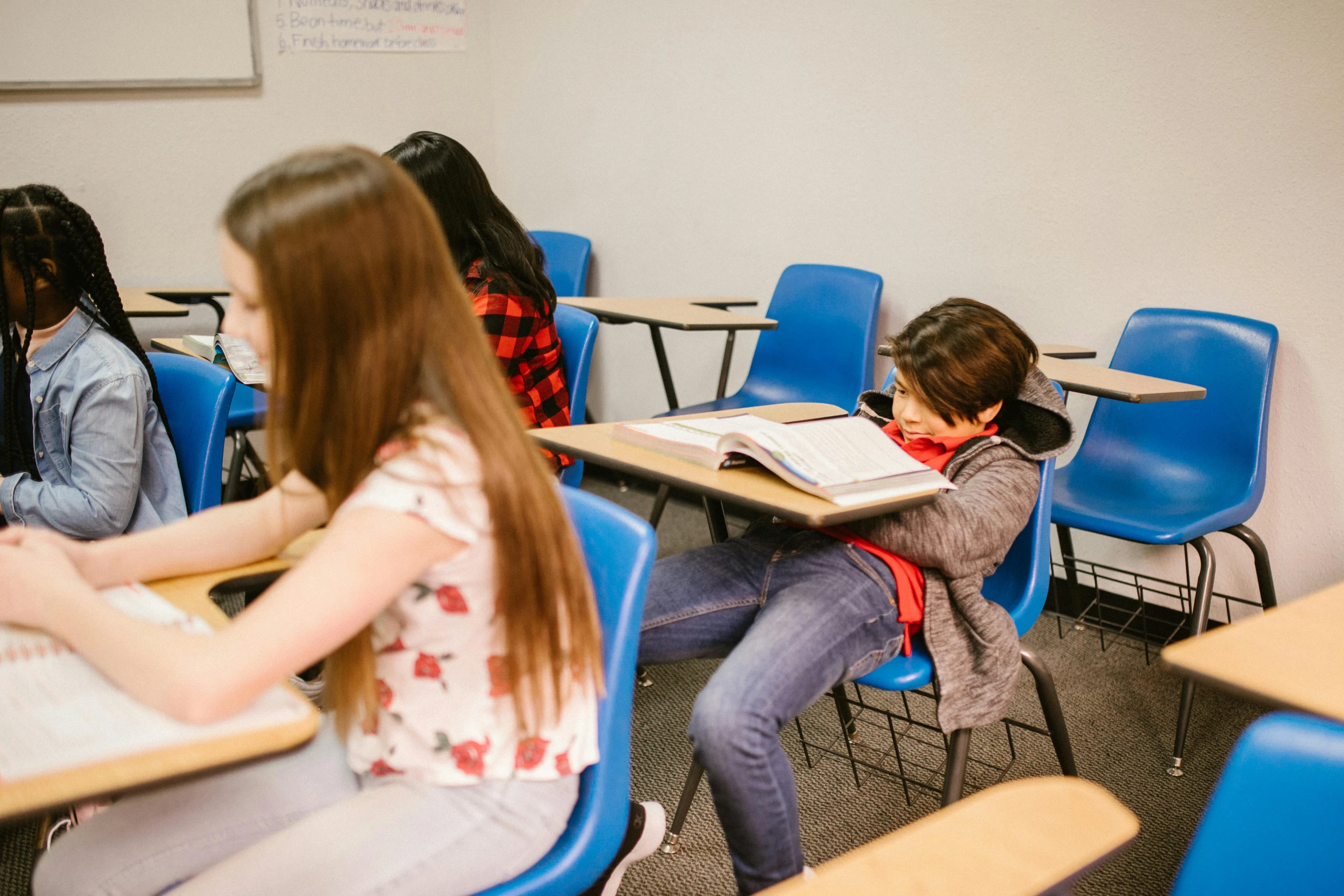 a group of children sitting at desks in a classroom, by Anna Findlay, pexels contest winner, incoherents, hunched shoulders, siting in a chair, rated t for teen, profile image