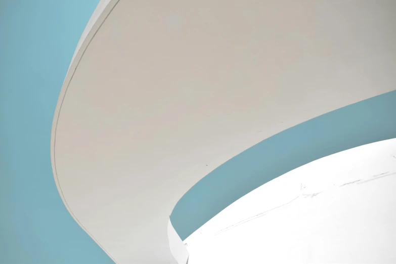 a white toilet sitting inside of a bathroom next to a blue wall, inspired by Ned M. Seidler, unsplash contest winner, postminimalism, stairs and arches, view from below, pale cyan and grey fabric, detail structure