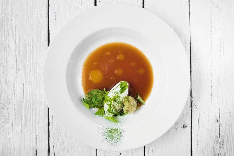 a white plate topped with soup and vegetables, inspired by Dietmar Damerau, detailed product image, caramel, rustic, full product shot