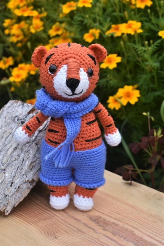 a stuffed animal sitting on top of a wooden bench, a tiger, crochet, fully dressed, thumbnail