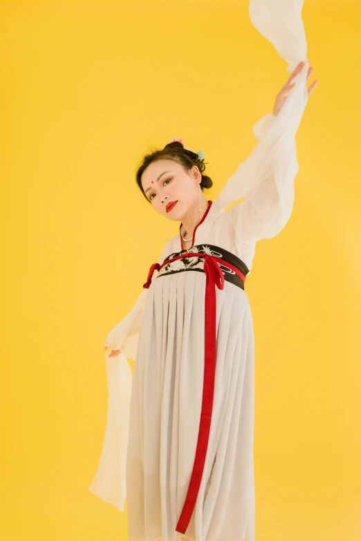 a woman in a white dress on a yellow background, an album cover, inspired by Tang Di, flickr, hanfu, pose(arms up + happy), authentic costume, cynthwave