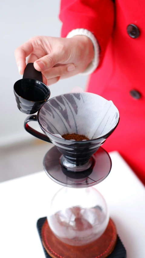 a woman in a red jacket pours a cup of coffee, a still life, unsplash, close up of iwakura lain, glass tableware, black watercolour, square