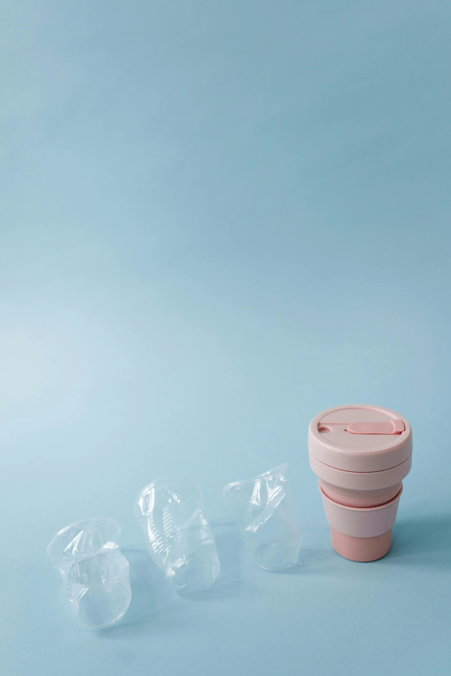 a pink cup sitting on top of a blue surface, unsplash, plasticien, landfill, bjarke ingels, in plastic, promo image