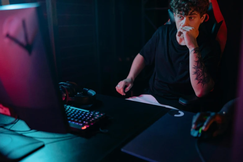 a man sitting at a desk in front of a computer, by Adam Marczyński, pexels contest winner, riot games, pouting, shroud, eating