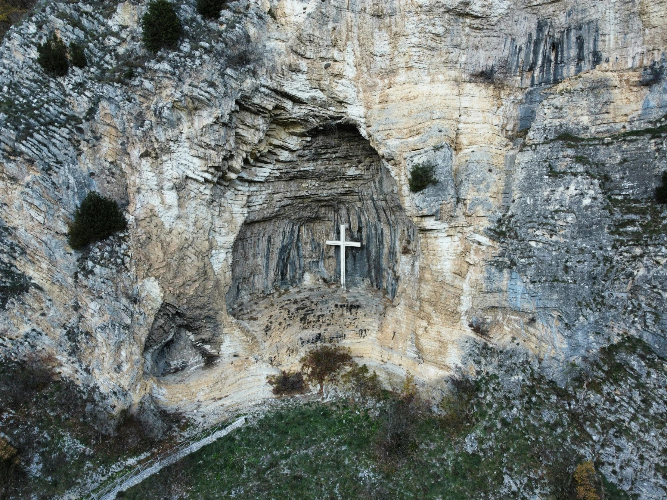 a cross carved into the side of a cliff, by Matthias Stom, pexels contest winner, les nabis, cave prison, uav, reliquary, 2 0 0 0's photo