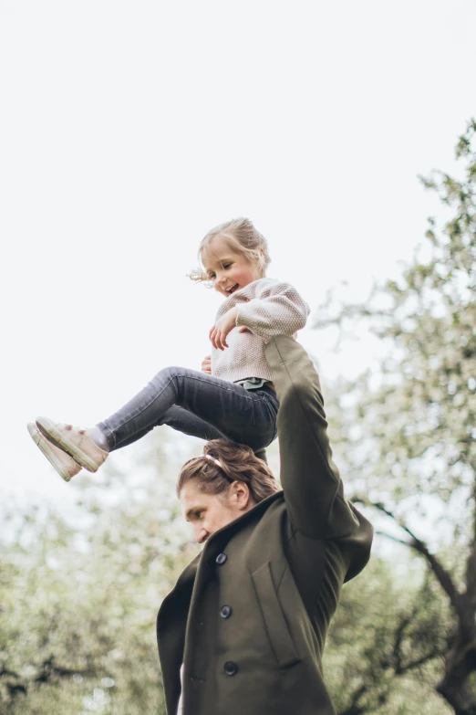 a man holding a little girl up in the air, pexels, square, springtime, canopy, brand