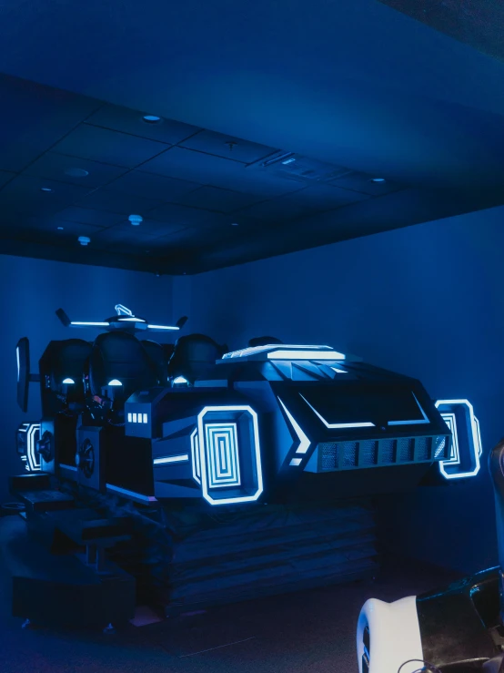 a man playing a video game in a dark room, inspired by Syd Mead, unsplash, interactive art, full view of a car, blue submarine no 6, amusement park interior design, rides