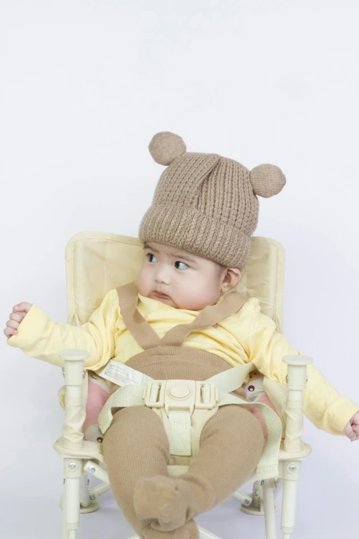 a baby sitting in a chair wearing a bear hat, trending on reddit, mingei, high quality product photo, brown:-2, real shot, ross tan