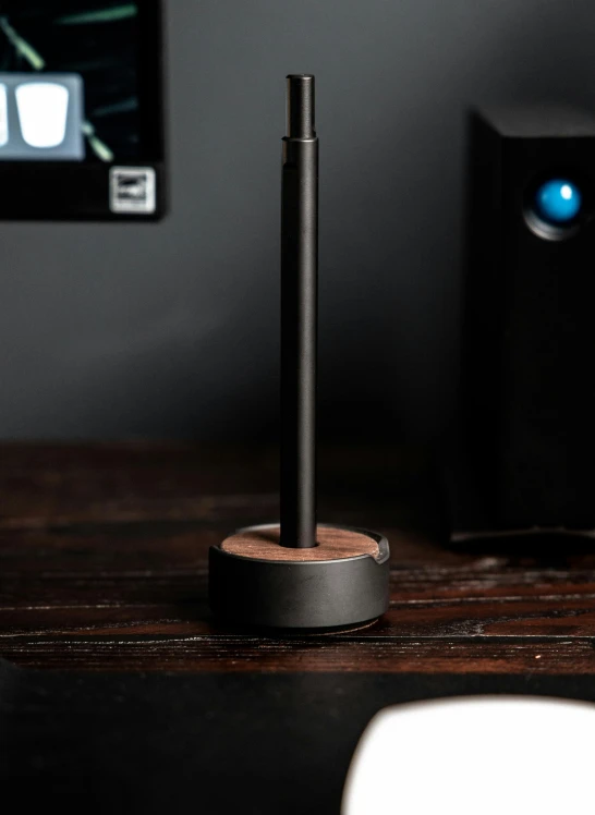 a computer monitor sitting on top of a wooden desk, standing microphones, all black matte product, brown, hero shot