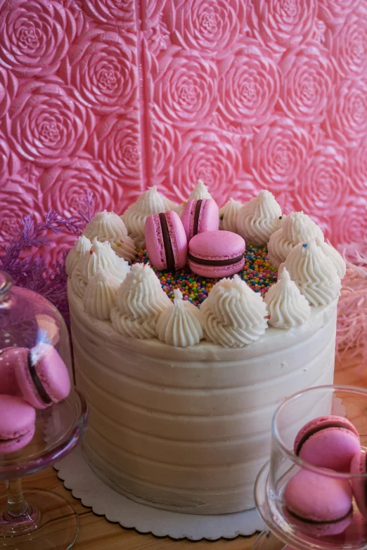 a close up of a cake on a table, a pastel, hot pink, macaron, backdrop, whipped cream