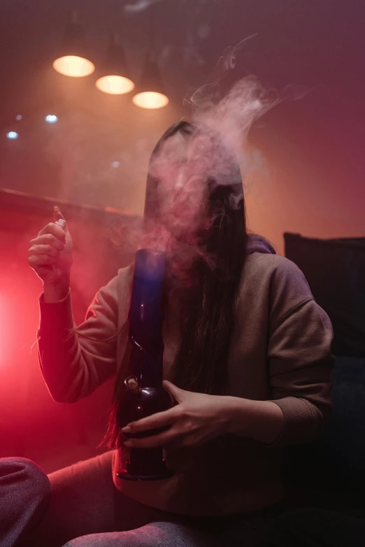 a man sitting on a couch smoking a cigarette, inspired by Elsa Bleda, trending on pexels, renaissance, from a huge red glass bong, at a rave, an asian woman, blue and purple vapor