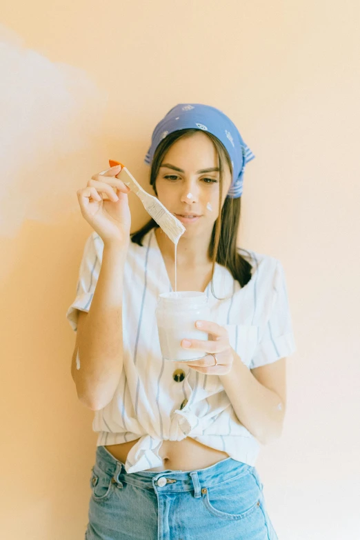 a woman brushing her teeth with a toothbrush, a picture, inspired by Elsa Bleda, trending on pexels, renaissance, drinking cough syrup, pastel clothing, wearing a headband, isabela moner