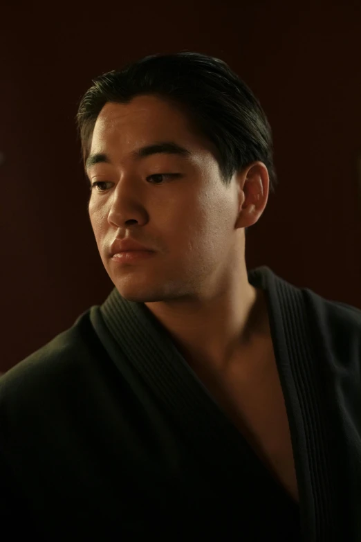a man in a kimono standing in front of a mirror, in a movie still cinematic, wearing dark green robes, headshot, paul kwon