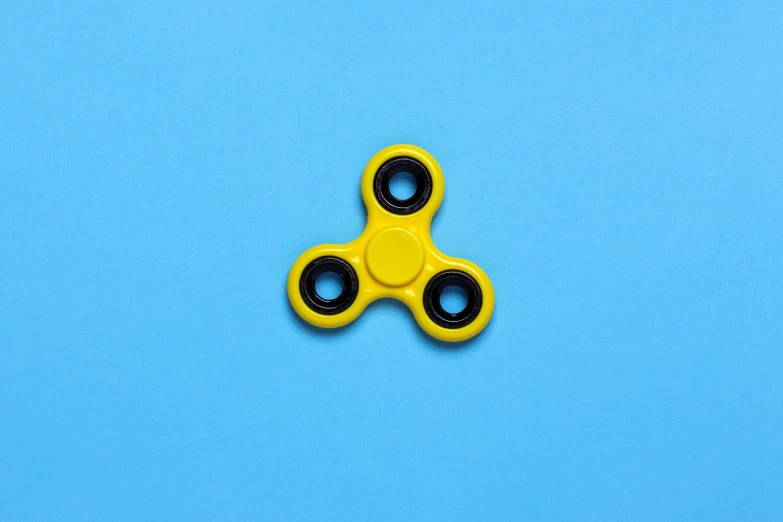 a yellow fidgetr on a blue background, pexels, spinning, black on white background, magnetic, japanese