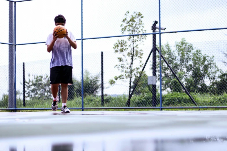 a man holding a basketball on top of a court, a park, facing away from the camera, playing games, instagram photo