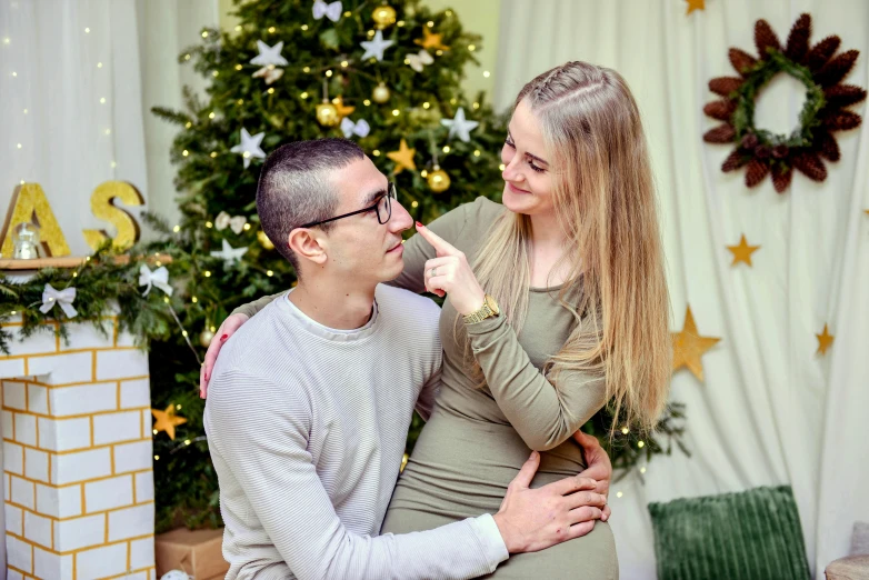 a man and a woman in front of a christmas tree, a portrait, pexels contest winner, romanticism, avatar image, maternity feeling, russian girlfriend, casually dressed