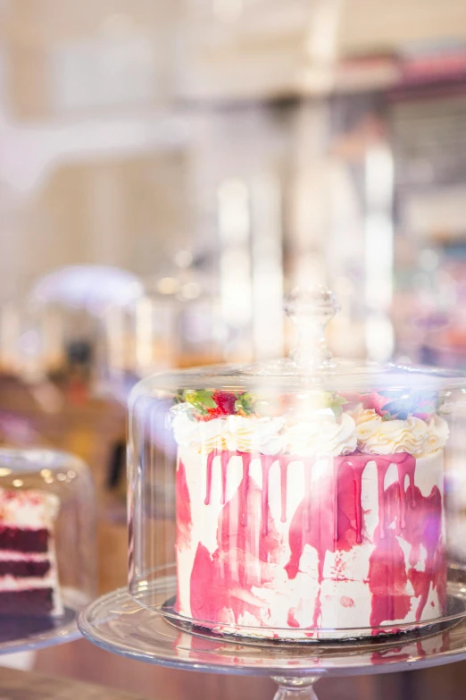 a cake sitting on top of a glass plate, large sweet jars on shelves, zoomed in, event photography, pink