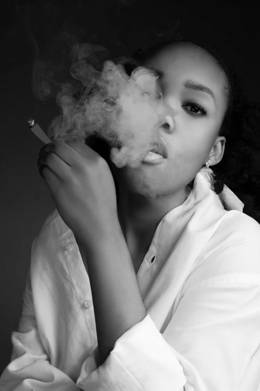 a black and white photo of a woman smoking a cigarette, an album cover, inspired by Carrie Mae Weems, unsplash, visual art, modelling, clothed in white shirt, thug life, puffs of smoke