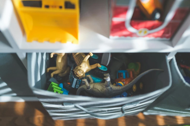 a close up of a shelf filled with toys, a picture, by Daniel Lieske, unsplash, plasticien, hiding large treasure chest, grey, high - angle view, sunny light