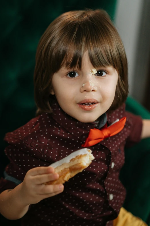 a little girl sitting in a chair eating a hot dog, an album cover, by Julia Pishtar, pexels, closeup at the food, beautiful boy, bun ), elegantly dressed