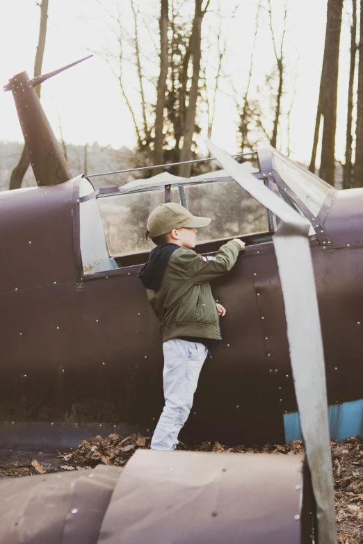 a little boy that is standing in front of a plane