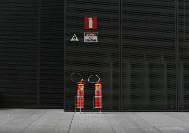 a couple of red fire hydrants sitting in front of a building, a photo, by Daniel Lieske, pexels contest winner, the matrix servers on fire, on a gray background, oxygen tank, torches on the wall