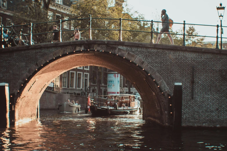 a boat that is going under a bridge, by Jan Tengnagel, pexels contest winner, happening, canals, casually dressed, promo image, hd footage