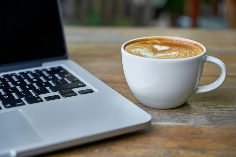 a cup of coffee next to a laptop computer, by Carey Morris, white, thumbnail, cappuccino, close up image
