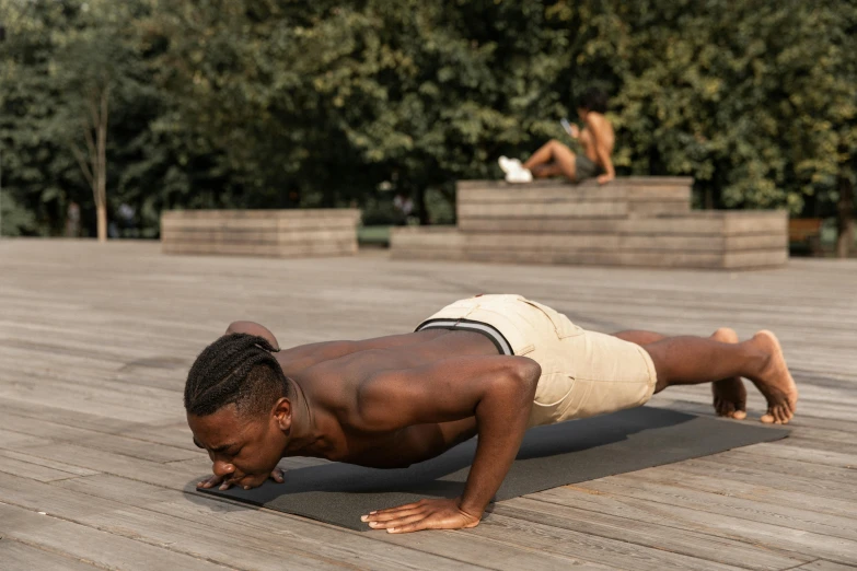 a man doing push ups on a wooden floor, by Carey Morris, pexels contest winner, figuration libre, outside on the ground, man is with black skin, lean man with light tan skin, thumbnail