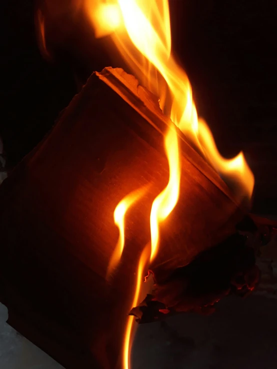 a close up of a pot with fire coming out of it, an album cover, by Gwen Barnard, unsplash, auto-destructive art, cardboard, a book, fire warning label, dark warm light