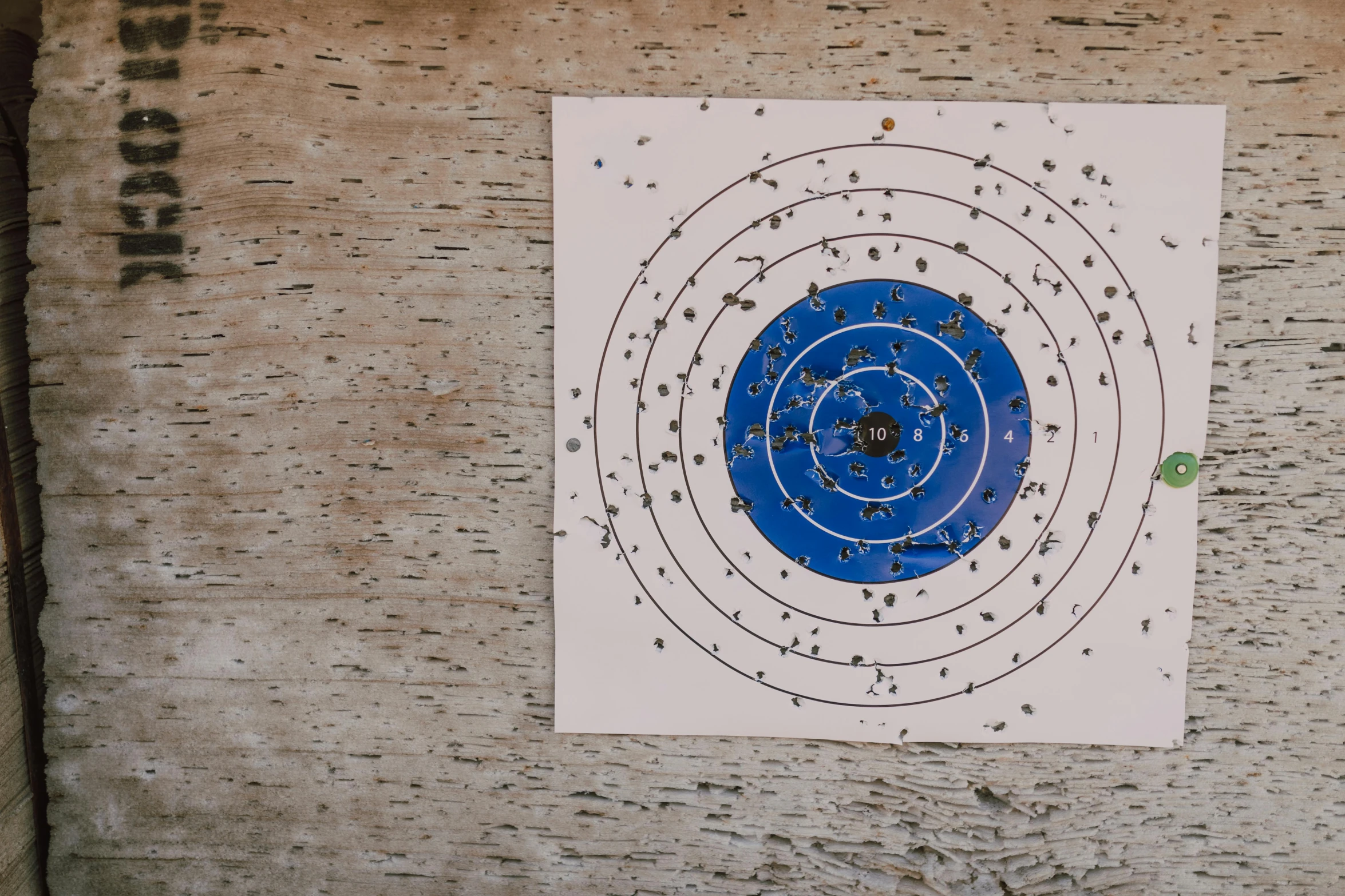 a blue and white target on a wooden wall, unsplash, papers on table, bullet tracers, full colour, gunner