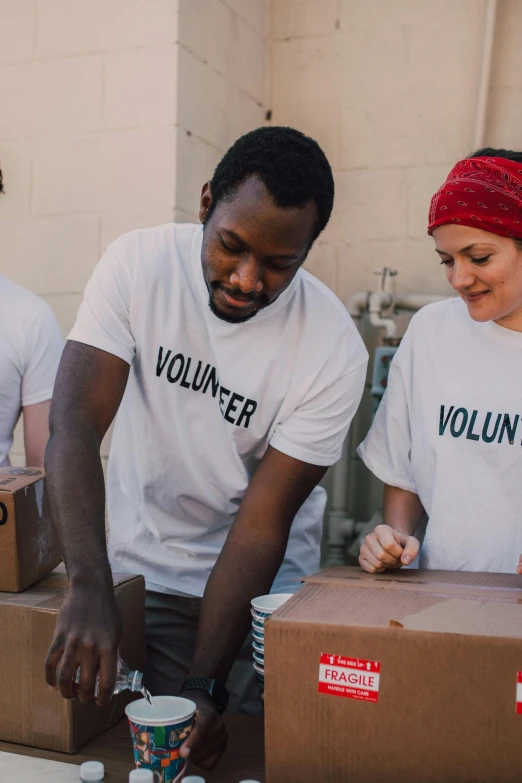 a group of people wearing volunteer t - shirts, a photo, by Arabella Rankin, trending on unsplash, process art, delivering parsel box, plating, african aaron paul, 15081959 21121991 01012000 4k