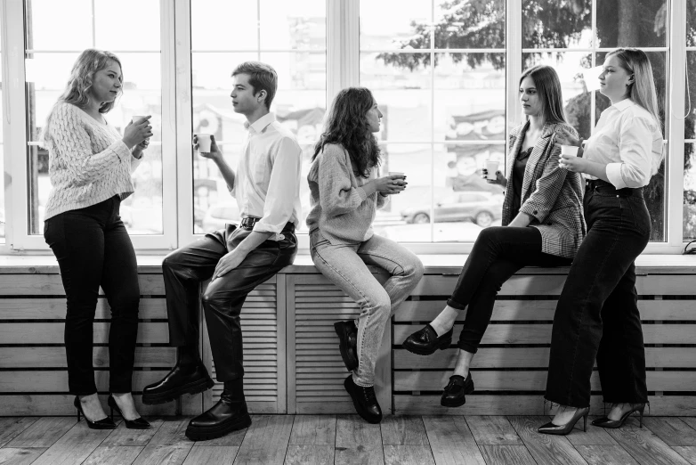 a group of people sitting on a window sill, a black and white photo, pexels, networking, android coffee shop, full body portrait of a group, complaints