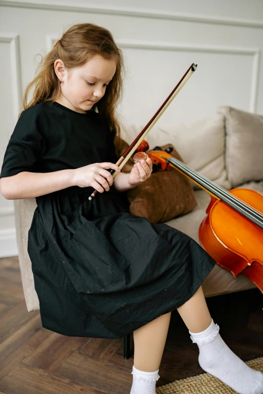 a little girl sitting on a couch playing a violin, pexels contest winner, full product shot, carefully designed, private school, thumbnail