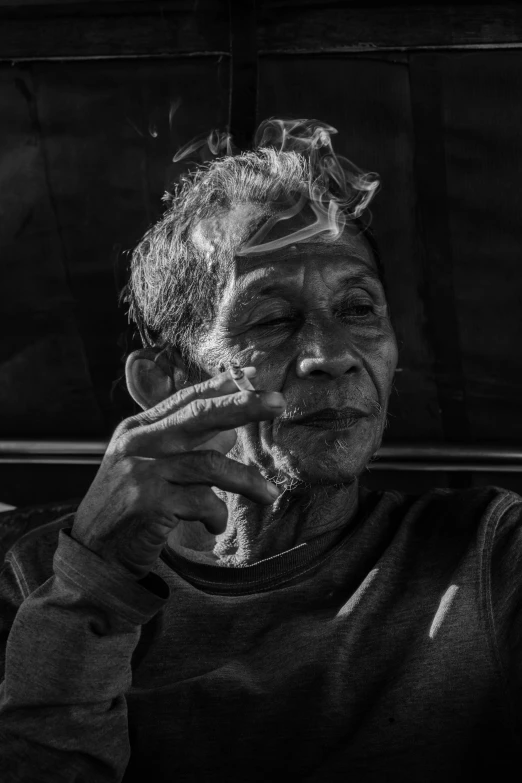 a black and white photo of a man smoking a cigarette, a black and white photo, pexels contest winner, sumatraism, two frail, portrait of a old, late afternoon, hand on cheek