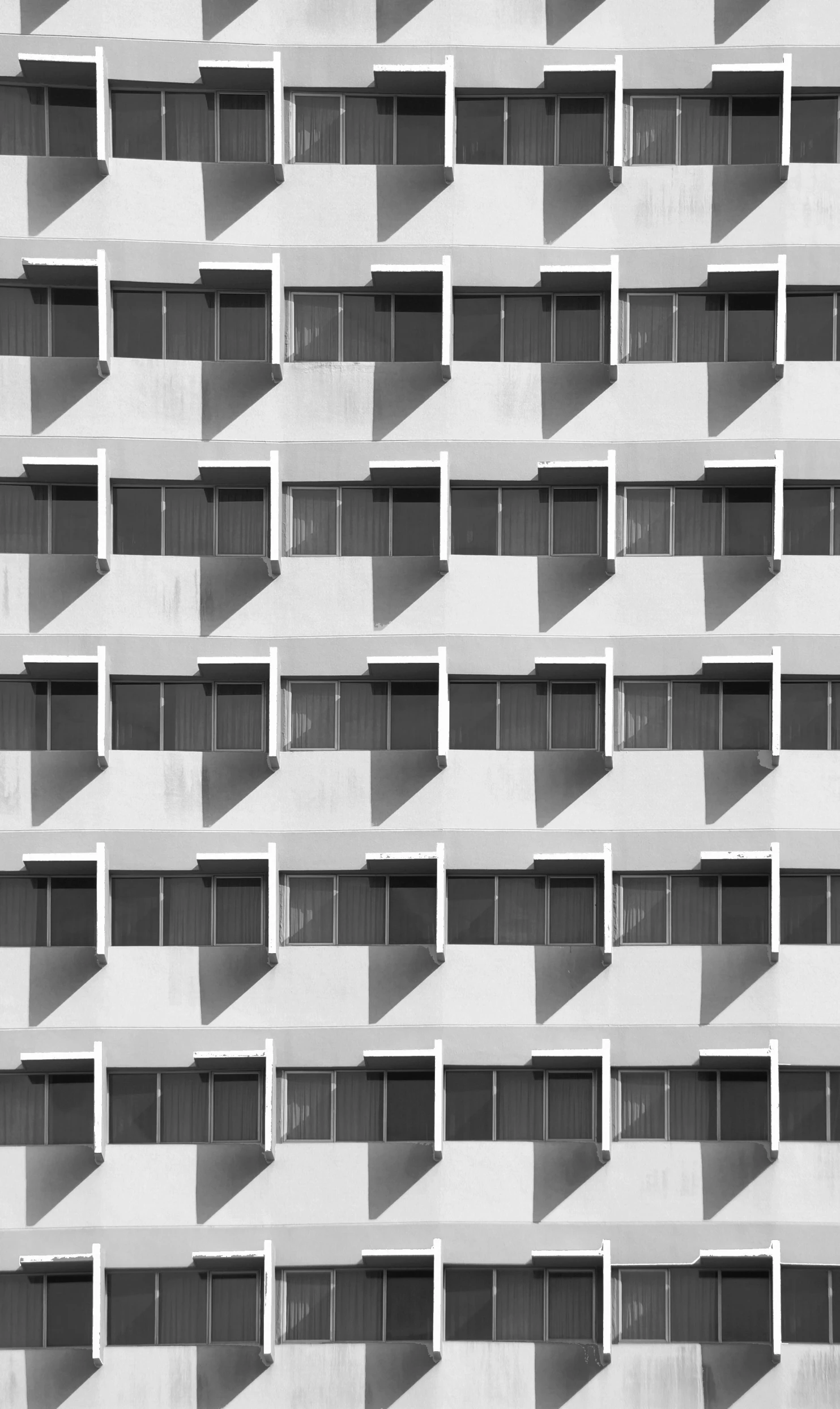 a black and white photo of a building, inspired by Ned M. Seidler, unsplash contest winner, repeating pattern, ffffound, white houses, crenellated balconies