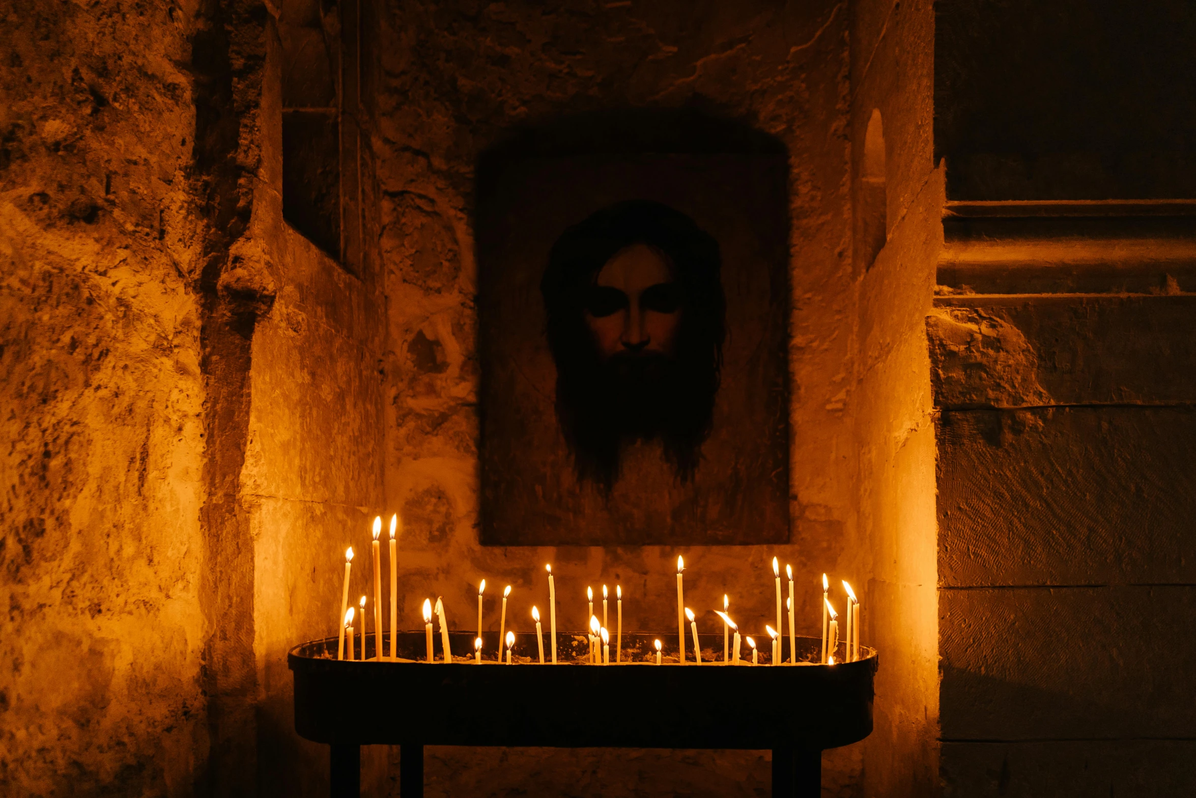 candles are lit in front of a picture of jesus, by Daniel Lieske, pexels, dimly lit underground dungeon, orthodox icon, located in a castle, profile image