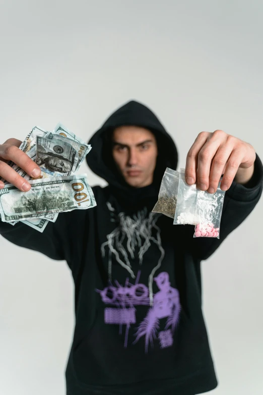 a man in a hoodie holding a bunch of money, an album cover, pexels contest winner, witchcore, young man in a purple hoodie, zyzz, movie photo