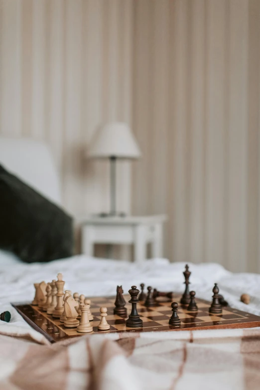 a close up of a chess board on a bed, by Andries Stock, unsplash, hotel room, on a white table, toys, brown