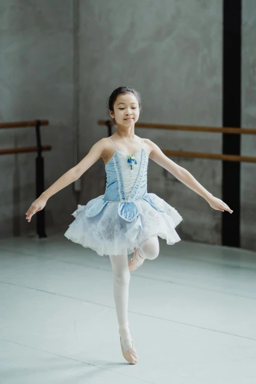 a little girl in a blue dress is dancing, by Elizabeth Durack, unsplash, arabesque, delicate embellishments, longque chen, standing and posing elegantly, ice blue