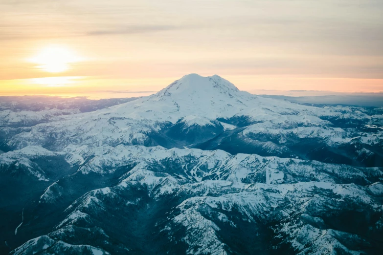 a snow covered mountain with a sunset in the background, a photo, by Morgan Russell, trending on unsplash, visual art, taken from a plane, cascadia, 2 0 2 2 photo, lush scenery