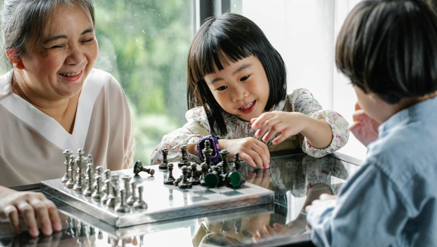 a woman and two children playing a game of chess, pexels contest winner, korean girl, thumbnail, robotics, high quality image