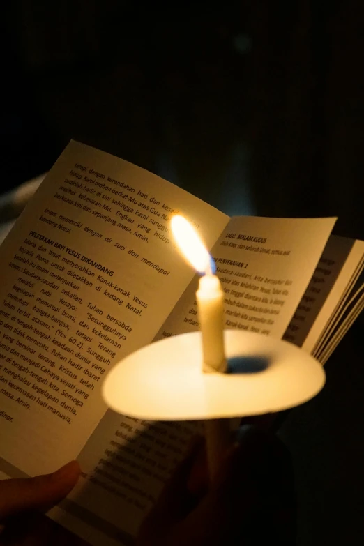 a person reading a book with a lit candle, may 1 0, greg rutwoski, dsrl photo, multiple stories