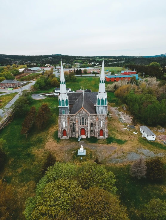 a large church sitting on top of a lush green field, drone photo, quebec, taken on go pro hero8, haunted gothic hotel