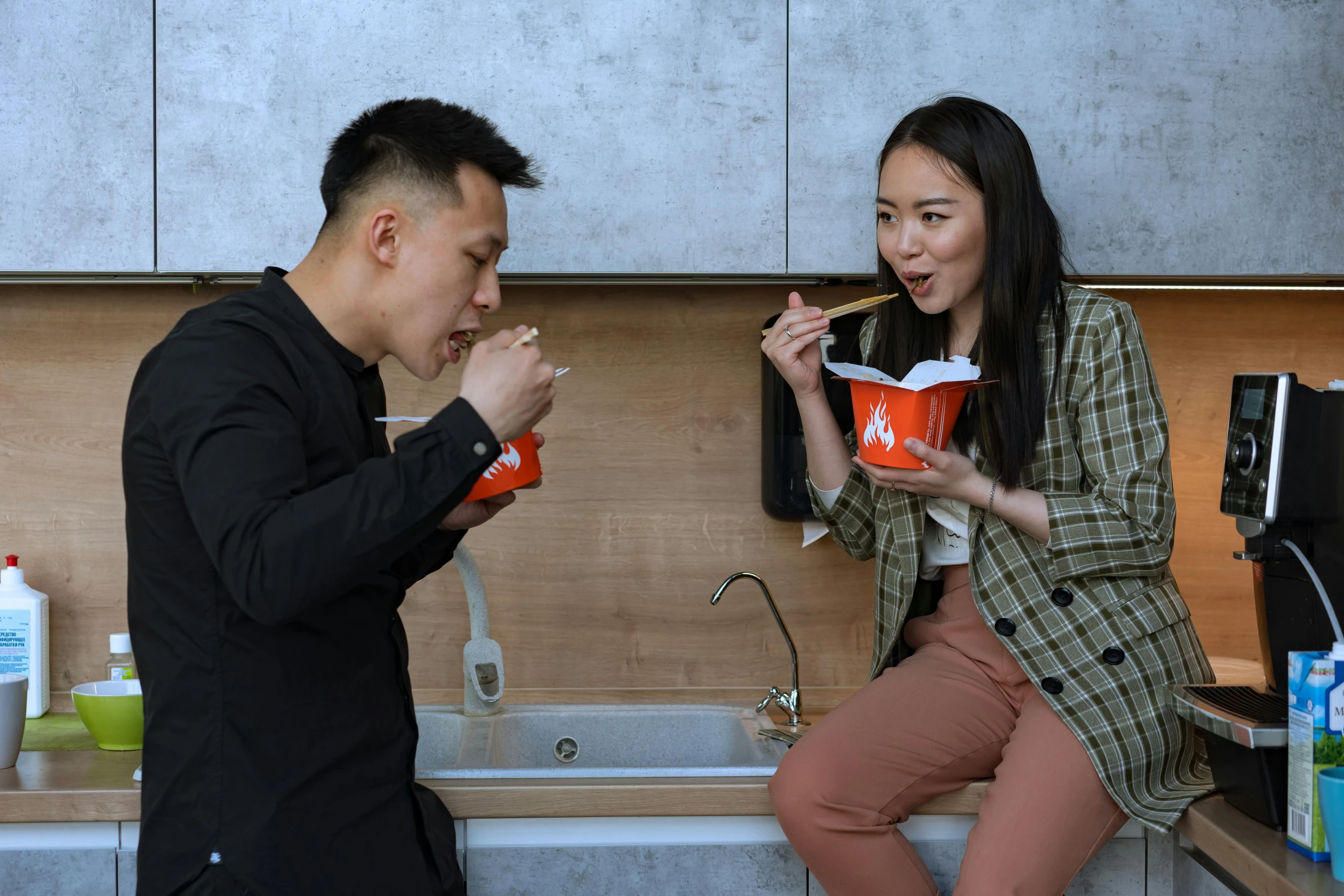 a man and a woman eating food in a kitchen, inspired by Wang Duo, holding a bucket of kfc, profile image, asian, noodles