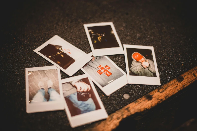 a pile of polaroids sitting on top of a table, inspired by Elsa Bleda, pexels contest winner, lying on the ground, photo booth, nighttime photography, a photo of a man