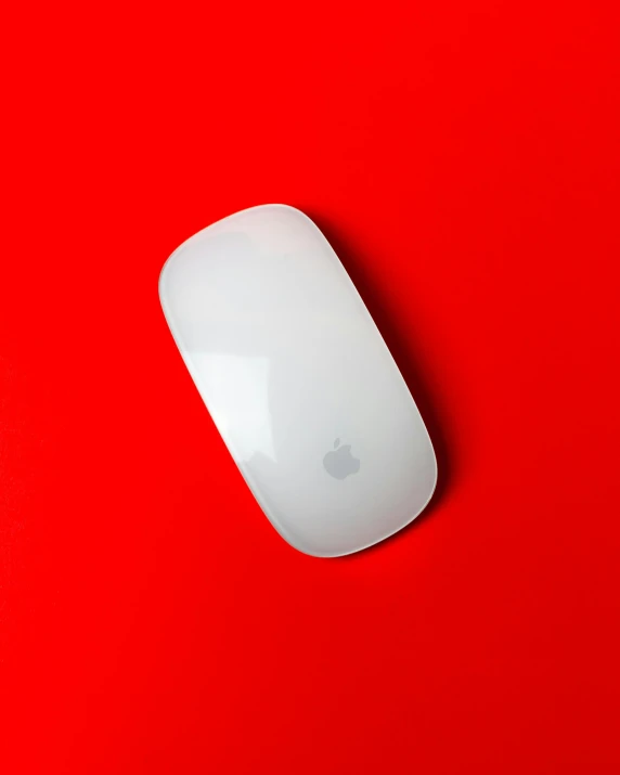 a white apple mouse sitting on top of a red surface, by Julia Pishtar, unsplash, silicone skin, thumbnail, mac